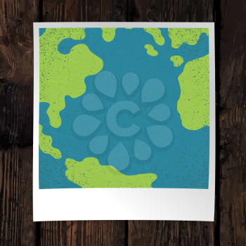 Photo frame with Earth snapshot closeup. Earth day concept. With space for text. On wooden background. Design template. 