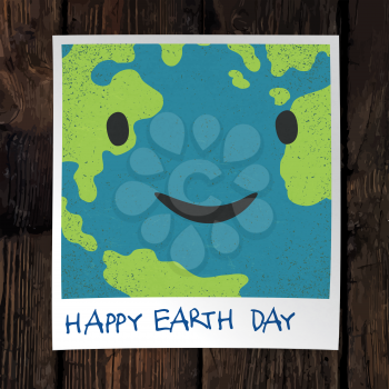Photo frame with Earth snapshot closeup. Earth day concept. On wooden background. 