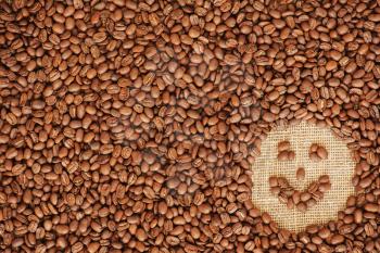 face coffee frame made of coffee beans on burlap texture