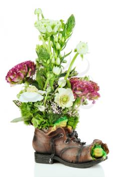 Flower bouquet arrangement centerpiece in old shoe with frogs isolated on white background.