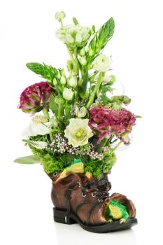 Flower bouquet arrangement centerpiece in old shoe with frogs isolated on white background.