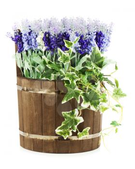 Composition of artificial flowers in old wooden barrel isolated on white background. Closeup.