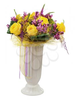 Floral bouquet of yellow roses and orchids arrangement centerpiece in vase isolated on white background. Closeup.