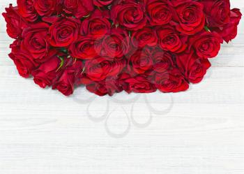 Colorful flower bouquet from red roses on white wooden background. Closeup.