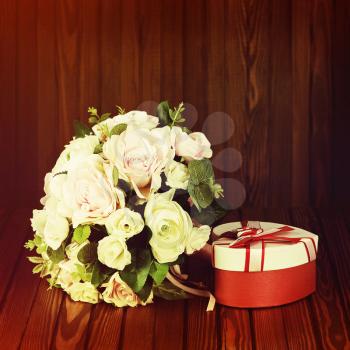 Beautiful wedding bouquet from white and pink roses with retro filter effect on wooden background
