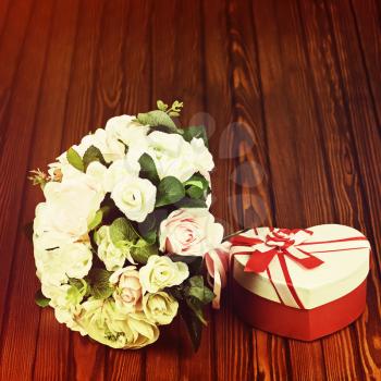 Beautiful wedding bouquet from white and pink roses with retro filter effect on wooden background.