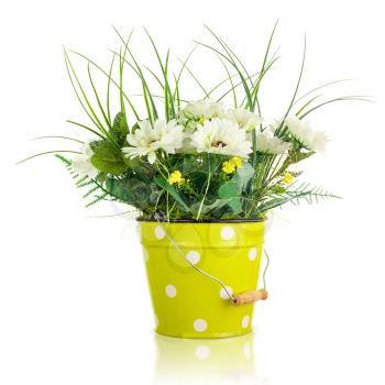 Bouquet from artificial flowers arrangement centerpiece in yellow metal toy bucket.