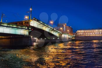 Night view of illuminated drawbridge (Foundry Bridge) on night river Neva water, one of the most familiar images of the Northern capital of Russia, Saint Petersburg.