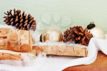 Abstract composition from birch logs, Christmas balls and cones.