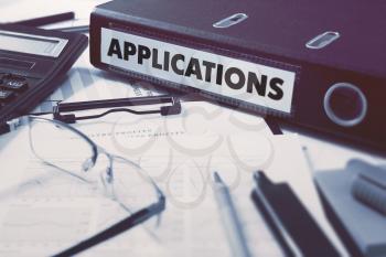 Applications - Office Folder on Background of Working Table with Stationery, Glasses, Reports. Business Concept on Blurred Background. Toned Image.