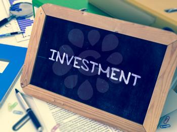 Investment Concept Hand Drawn on Chalkboard on Working Table Background. Blurred Background. Toned Image. 3D Render.