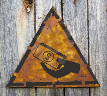 Royalty Free Photo of a Hand Giving Money on a Rusty Sign Against a Wooden Wall