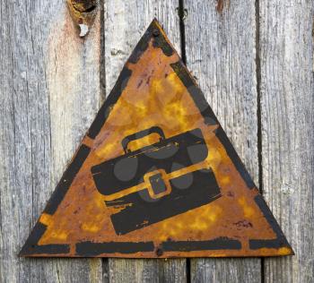 Royalty Free Photo of a Briefcase on a Rusty Sign Against a Wooden Wall