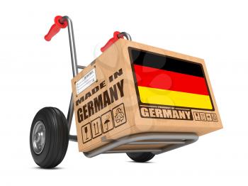 Cardboard Box with Flag of Germany and Made in Germany Slogan on Hand Truck White Background. Free Shipping Concept.