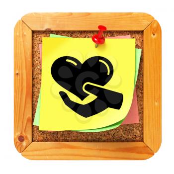 Charity Concept - Icon of Heart in the Hand on Yellow Sticker on Cork Message Board.