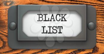 Black List - Inscription on File Drawer Label on a Wooden Background.