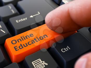 Finger Presses Orange Button Online Education on Black Keyboard Background. Closeup View. Selective Focus.