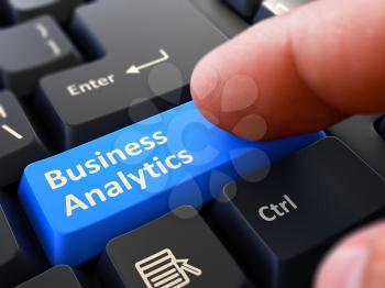 Business Analytics Button. Male Finger Clicks on Blue Button on Black Keyboard. Closeup View. Blurred Background.