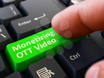 Monetizing OTT Video Green Button - Finger Pushing Button of Black Computer Keyboard. Blurred Background. Closeup View.