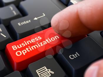 Business Optimization - Written on Red Keyboard Key. Male Hand Presses Button on Black PC Keyboard. Closeup View. Blurred Background.