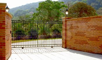 Royalty Free Photo of a Brick Fence and Iron Gate