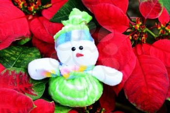 Stuffed snowman over christmas tree flowers