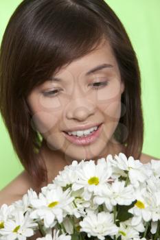 A naturally beautiful oriental woman make up free and holding a bunch of white flowers