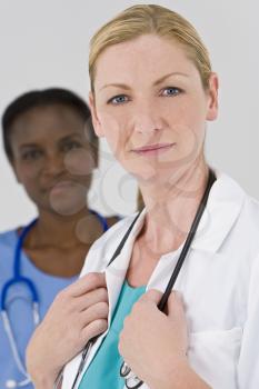 A female doctor with her African American colleague out of focus behind her
