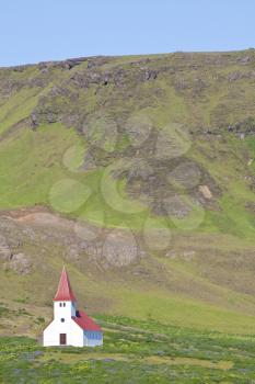 A Lutheran church sits alone on a hillside in Iceland