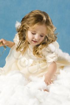 Photo of pretty girl in angelic costume on a blue background