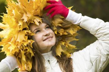 Portrait of smiling young woman wearing wreath of maple leaves