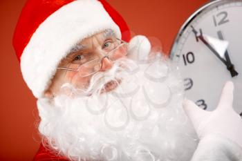 Photo of Santa pointing at clock showing five minutes to midnight