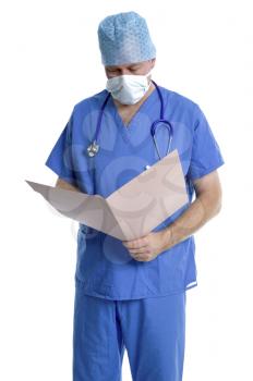 Surgeon in scrubs examining his patients notes.