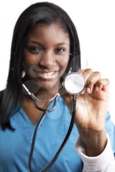 An isolated shot of an african american nurse holding a stethoscope (focus on the stethoscope)