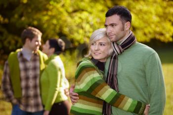 Young love couples hugging and walking in park outdoor at autumn, smiling.