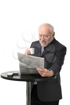 Portrait of happy senior businessman drinking coffee reading newspaper, laughing, white background.