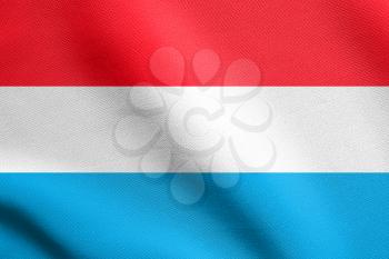 Flag of Luxembourg waving in the wind with detailed fabric texture. Luxembourgish national flag.