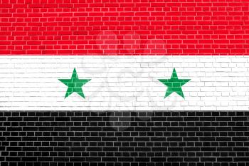 Flag of Syria on brick wall texture background. Syrian national flag.