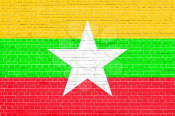 Flag of Myanmar on brick wall texture background. Myanmar national flag.