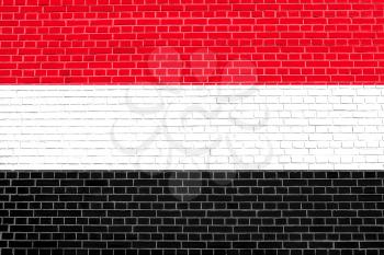 Flag of Yemen on brick wall texture background. Yemeni national flag.