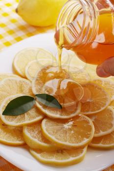 pour honey lemon slices on a plate