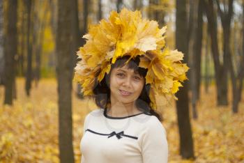Girl in autumn park with maple leaves.
