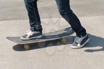 Skateboarder riding a skateboard on asphalt.