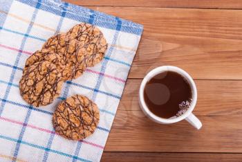 Cup of tea and oatmeal cookies on a wooden table.