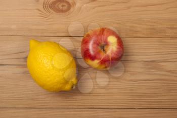 Lemon and apple on a wooden background. View from above .