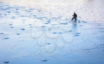Belarussian Fisher On Winter Frozen River. Nature Background