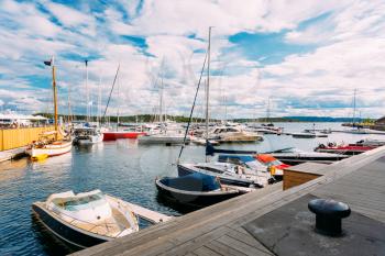Oslo, Norway. The Yachts And Boats Moored At City Quay At Aker Brygge District In Sunny Summer Day. Scenic Nautical Seascape With Blue Sky.