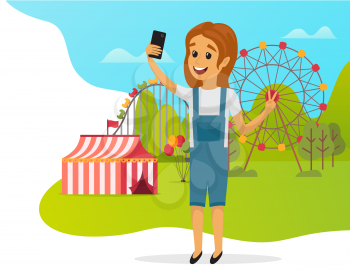 Girl is taking selfie during joyride. Child is photographed on phone camera. Kid with smartphone is posing for self portrait photo. Character making selfie photo against background of amusement park