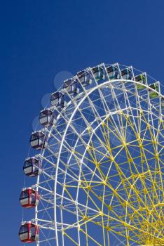 Ferris wheel on the background of blue sky