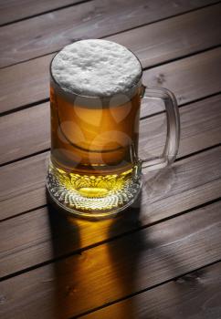 Mug of beer on wooden  background